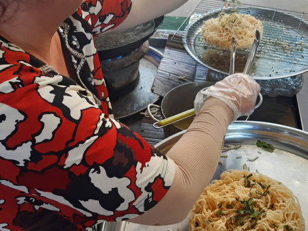 Vietnamese woman cooking Bun Gao, round rice noodles. Asian cook preparing Asian food. Eastern culture and civilization.の写真素材