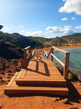 Wooden walkway leading to a pristine sandy beach. Idyllic coastal landscape. Wooden bridge and environmentally friendly construction.の写真素材
