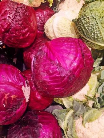 Close-up of a variety of bulk cabbages. Background of cabbages, red cabbages, and natural cauliflowers. Healthy eating. Seasonal vegetables. Freshly picked vegetables for sale.の写真素材