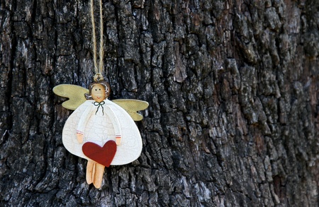 Wooden Angel with heart against tree bark の写真素材