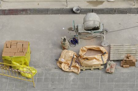 A concrete mixer with sand, bricks.の写真素材