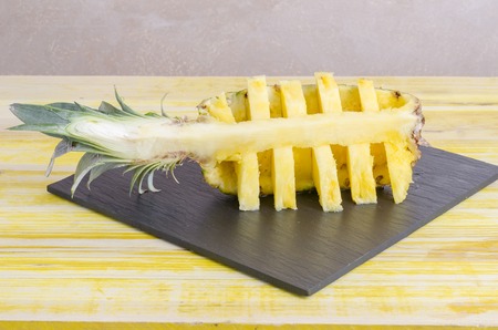 Quarter of cut pineapple On slate dish, horizontal.の写真素材
