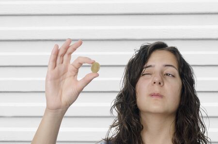 Young woman holding up Euro coin.の写真素材