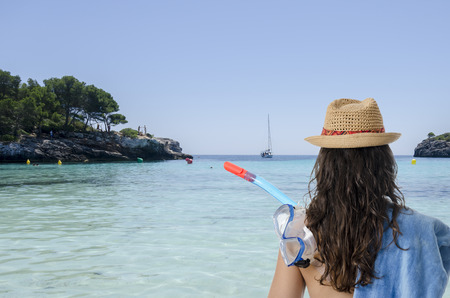 Girl back with towel, snorke, and hat in Menorca, Spain.の写真素材