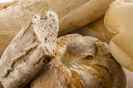 Freshly baked traditional breads on wooden table.の写真素材