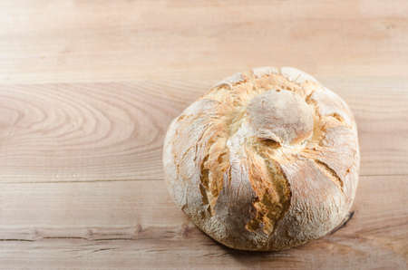 Freshly baked traditional bread on wooden table.の写真素材