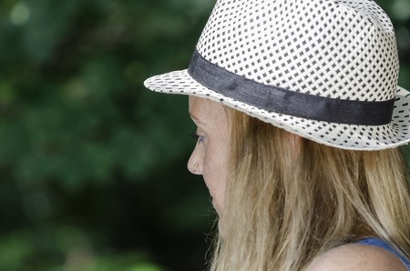 Attractive woman enjoying her time outside in park with hat.の写真素材