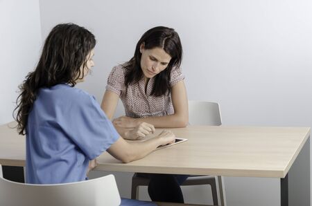 Young doctor/ physiotherapist with her consultation with a woman patient.