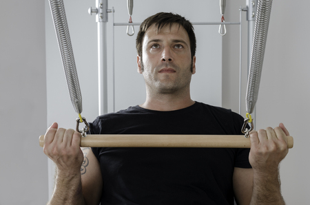 Pilates aerobic instructor man in cadillac fitness exercise