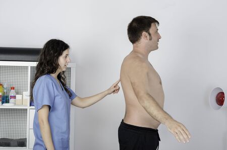 Physiotherapist doing a visual exploring, static/ dinamic positition, man patient.の写真素材