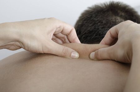 Physiotherapist doing a manual testing over dorsal spine, pull and roll. Massage.の写真素材