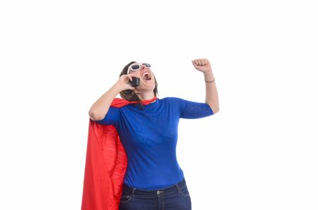 Woman superhero with red cape talking on the phone, white background.の写真素材