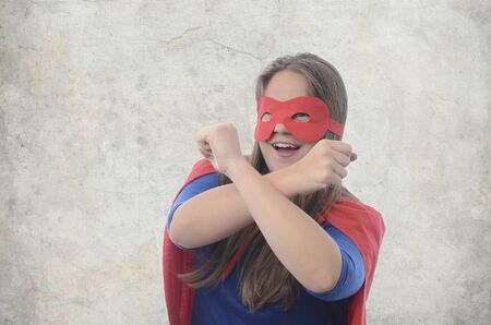 Woman superhero with red cape, gray background.の写真素材