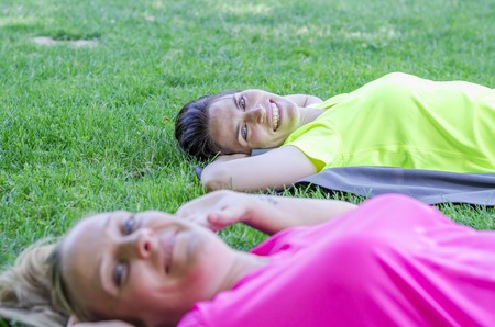 Two women happy are doing sport on fresh grass green.の写真素材