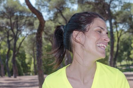 Woman is running and smiling through the trees.の写真素材