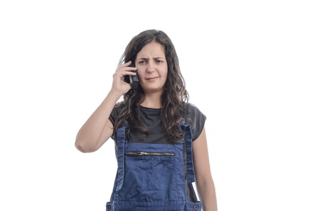 Worker woman talking on the phone over white background.の写真素材