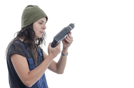 Worker woman with overalls and drill over white background.の写真素材
