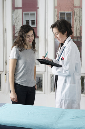 Female patient and doctor in examination room with stretcherの写真素材