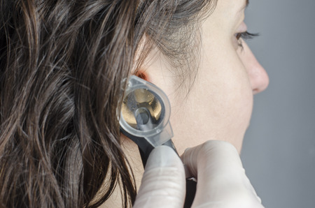Detail of woman doctor using otoscope with a girl patient.の写真素材