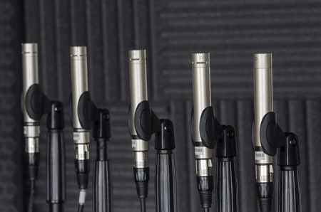 Condenser microphones placed in microphone stands in a lab of sound. Engineers make innovative soundsの写真素材