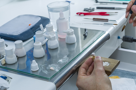 Closeup of dental technician applying ceramics to teeth before put into furnaceの写真素材