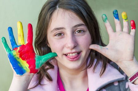 Happy girl showing her hands painted in bright colors.の写真素材