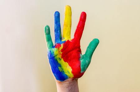Girl hand painted in colorful paints ready for hand prints.の写真素材