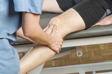 Chiropractor /physiotherapist doing a knee massage