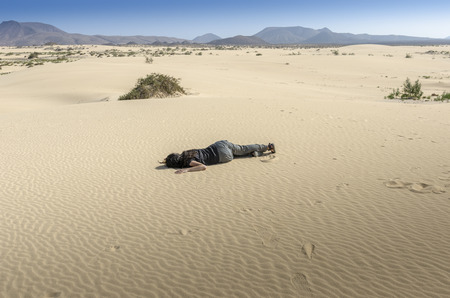 Woman fainted in desert sand.の写真素材
