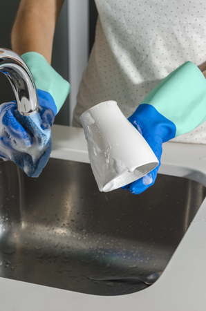 Closeup of woman washing a glass in the sink.の写真素材