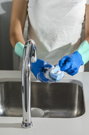 Woman washing a glass in the sink.の写真素材