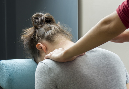 Chiropractor is doing a  office massage on chair.の写真素材