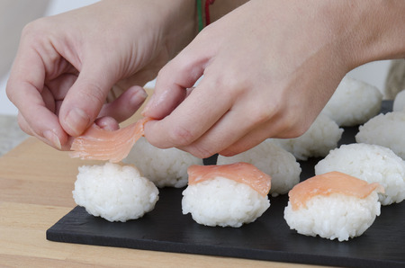 Woman is doing a sushi nigiri.の写真素材