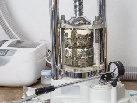 Dental technician is working with a dental flask of a complete upper on cast.のeditorial素材