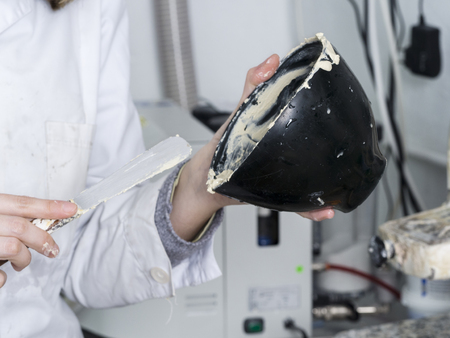 Dental technician is working with a dental flask of a complete upper on cast.