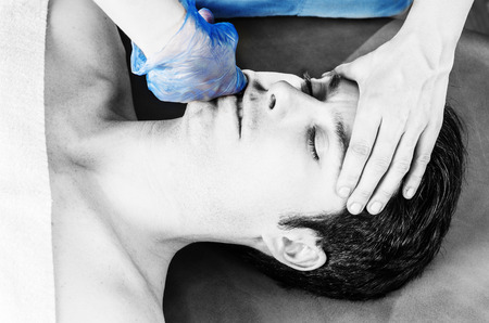 Physiotherapist is doing intraoral technique of massage masseter muscle.の写真素材