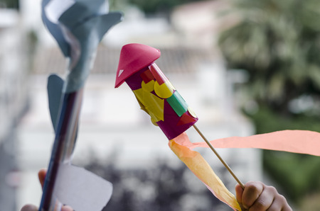 Child playing with a handmade rocket by a kid.