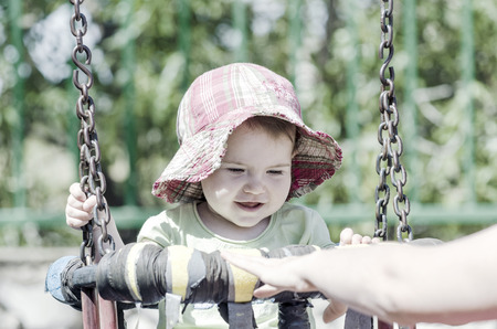 Happy baby with her mother in a swing.の写真素材