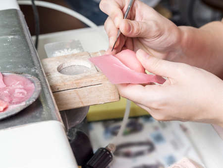 Dental technician doing partial dentures of acrylic resins. Constructing a palate of wax.の写真素材
