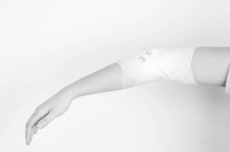 Compression bandage to inflammation, application of figure of eight bandage in silhouette isolated on white backgroundの写真素材