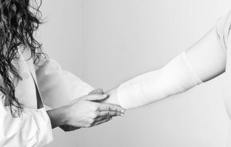 Compression bandage to inflammation, application a spiral bandage. application a spiral bandage in silhouette.の写真素材