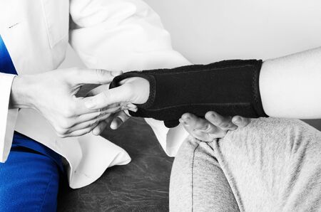 Doctor is checking the wrist to a patient after putting a wristband in silhouette, color and black and white.の写真素材