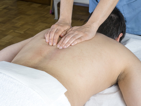 Chiropractor, physiotherapist is giving a back massageの写真素材