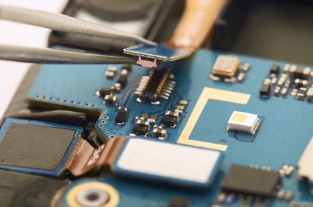 Disassembly of smartphone showing electrical board inside. The phone is fixing