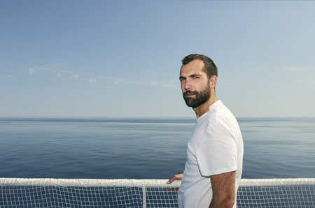 Handsome man on the deck of a ship during holidayの写真素材