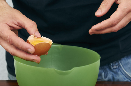 the cook separates the yolk in the eggの写真素材