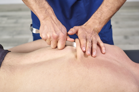 Therapist doing diacutaneous Fibrolysis, of the hooks healing treatment on man's back. Alternative medicine. Chiropractic, osteopathy, manual therapy, acupressureの写真素材