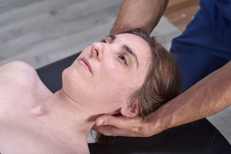 Physiotherapist doing a mobilization neck of female patient. Manual therapy.  Neurological physical examination. Osteopathy, Chiropracticの写真素材
