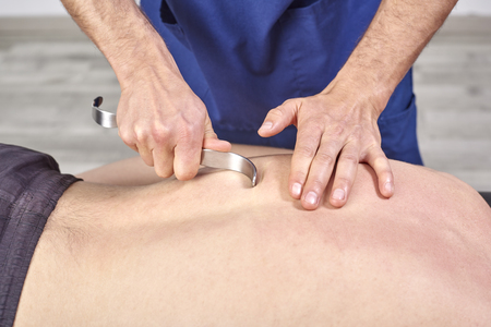 Therapist doing diacutaneous Fibrolysis, of the hooks healing treatment on man's back. Alternative medicine. Chiropractic, osteopathy, manual therapy, acupressureの写真素材