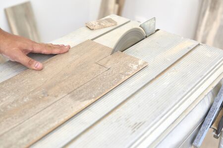 Carpenter cutting a laminate wood before to installing on the floorの写真素材